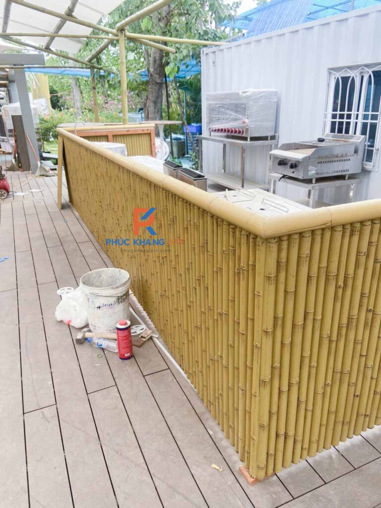 Quầy bar sân vườn được ốp tre nhựa tạo phong cách mộc mạc.